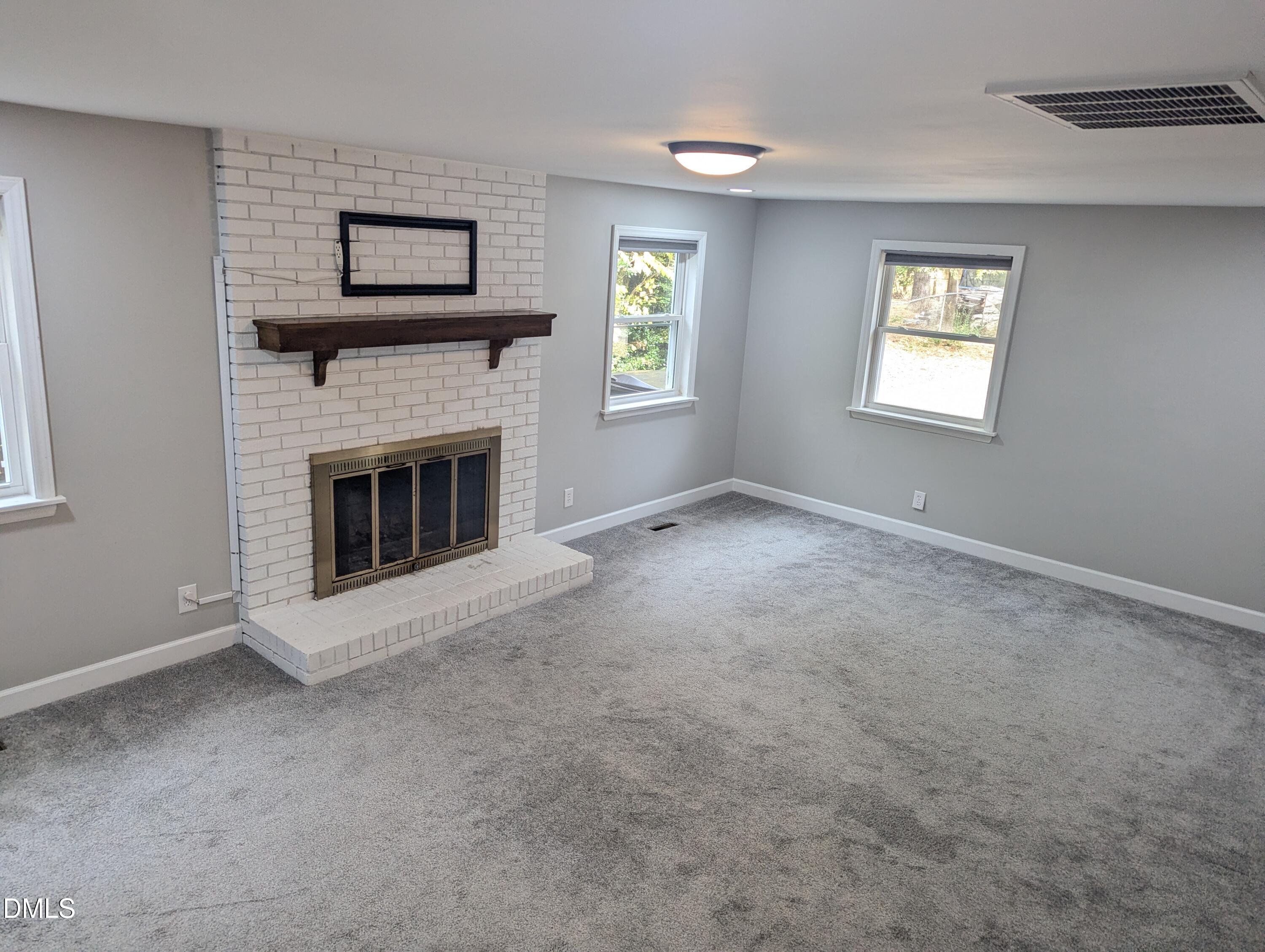 4011 Garrett Road Durham, NC 27707 - Photo 10 of 21 a view of an empty room with window and fireplace