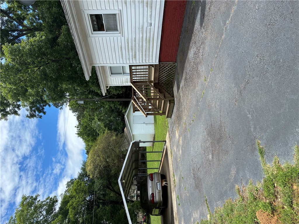 3407 New Pond Road Anderson, SC 29626 - Photo 11 of 16 A well-maintained side yard features a covered carport and convenient access to the structure's entry.