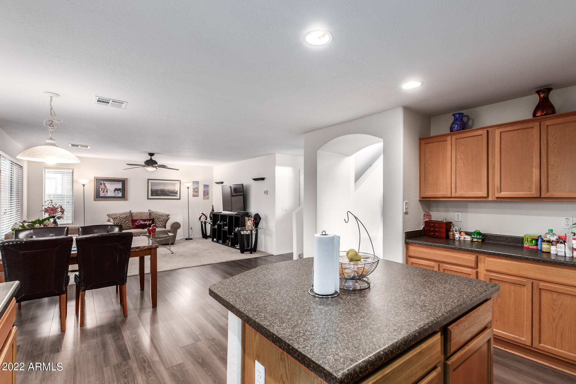 3790 West South Butte Road Queen Creek, AZ 85144 - Photo 13 of 40 a kitchen with stainless steel appliances granite countertop a sink dishwasher a stove a dining table and chairs with wooden floor