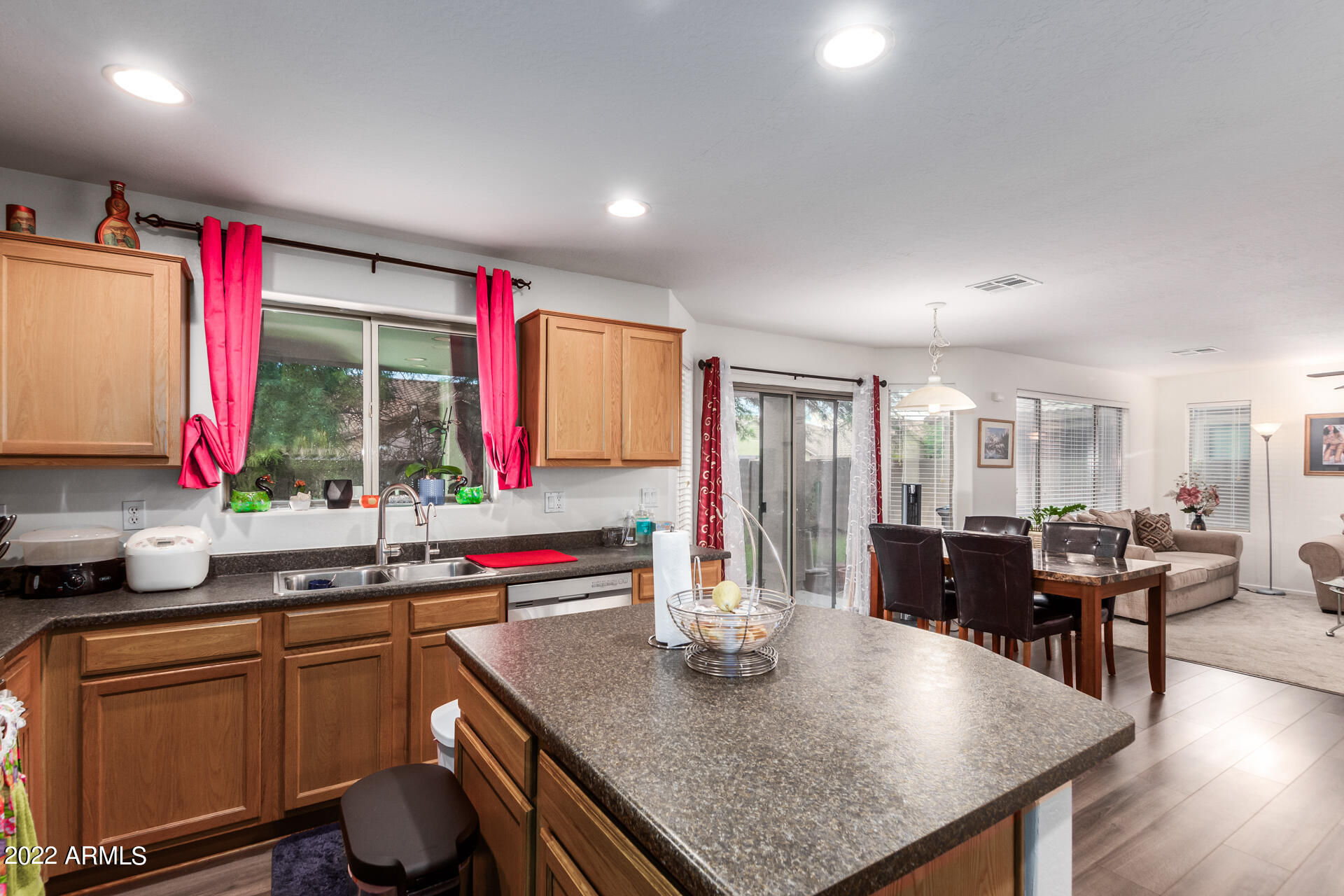 3790 West South Butte Road Queen Creek, AZ 85144 - Photo 15 of 40 a kitchen with stainless steel appliances granite countertop a sink dishwasher and a dining table with wooden floor