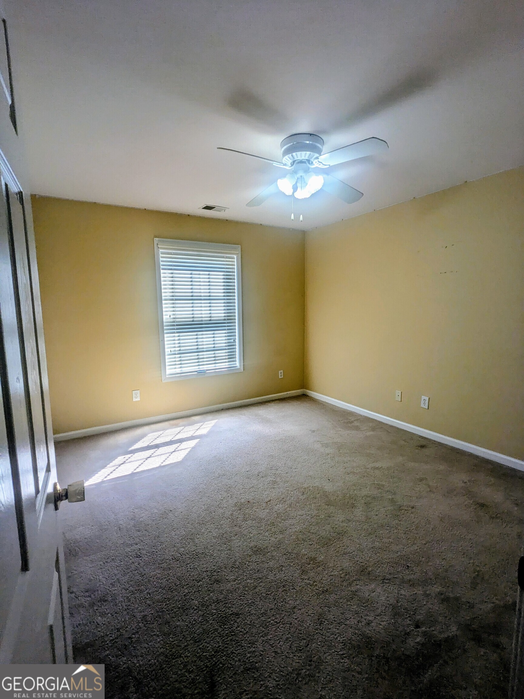 137 Village Green Circle Tyrone, GA 30290 - Photo 19 of 30 an empty room with windows and chandelier fan