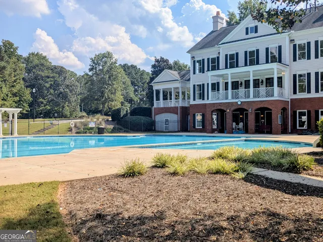 a view of a house with swimming pool and a yard