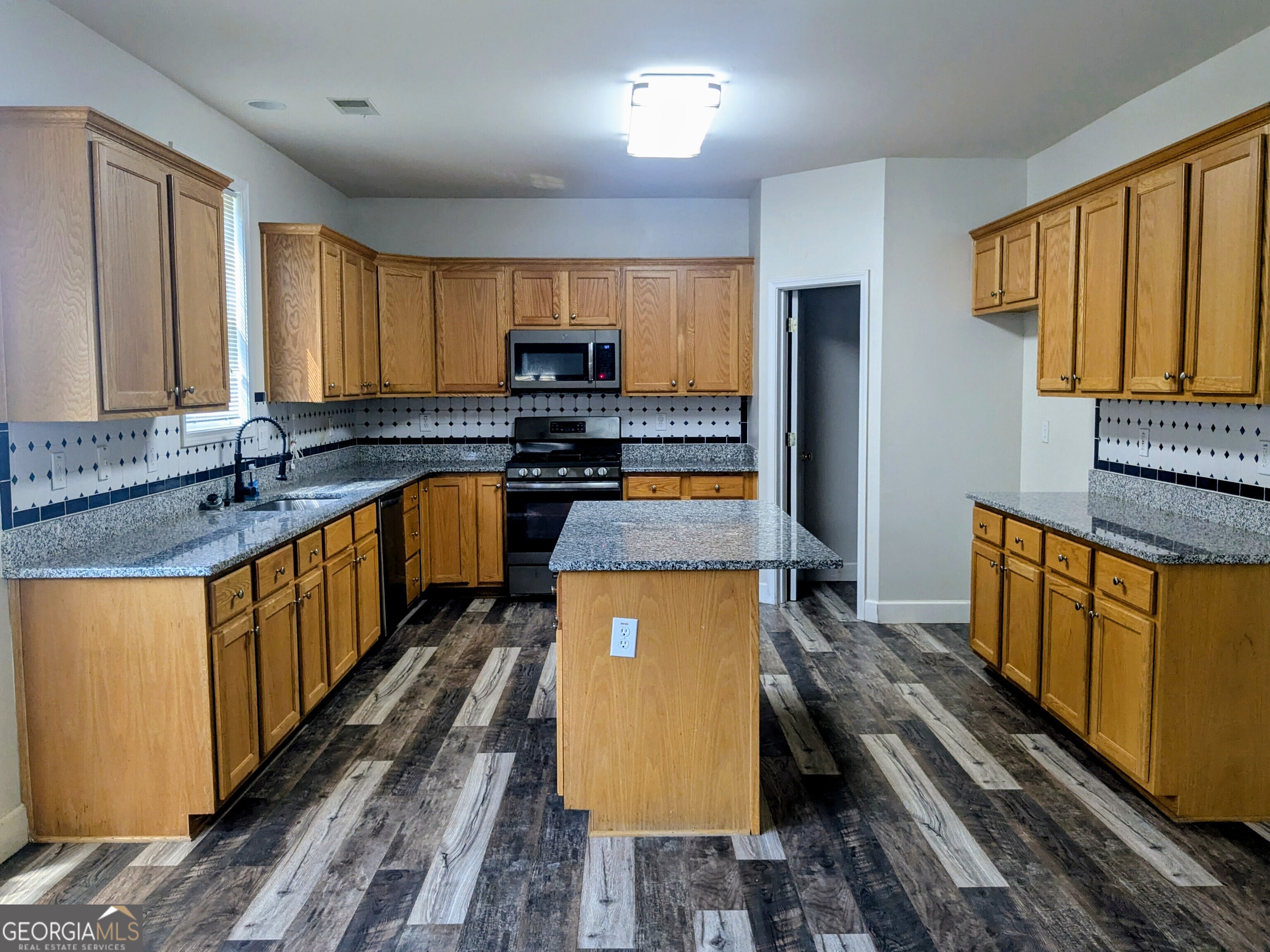 137 Village Green Circle Tyrone, GA 30290 - Photo 5 of 30 a kitchen with stainless steel appliances a stove a sink and a refrigerator