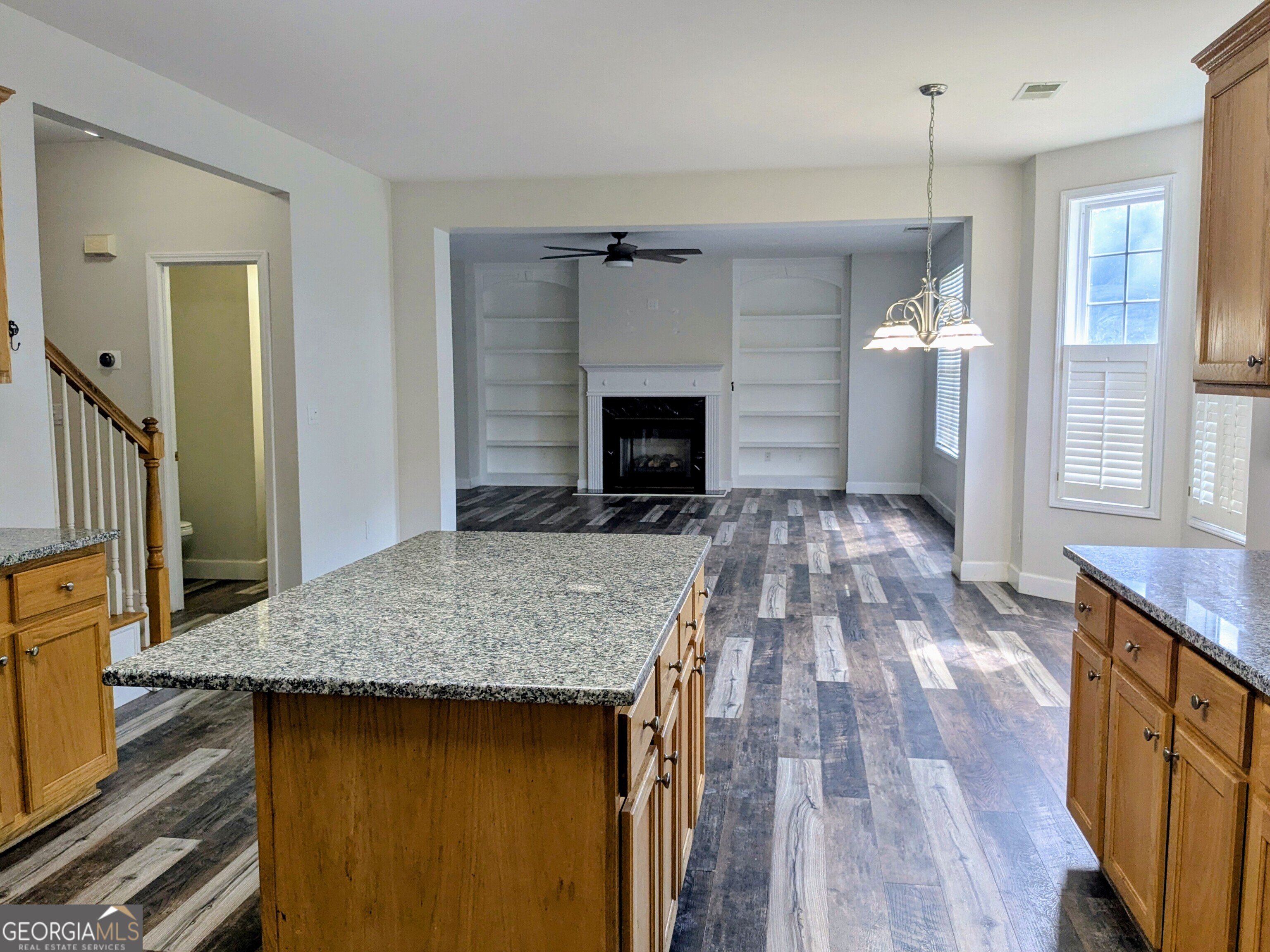 137 Village Green Circle Tyrone, GA 30290 - Photo 6 of 30 a kitchen with kitchen island a wooden floor and a fireplace