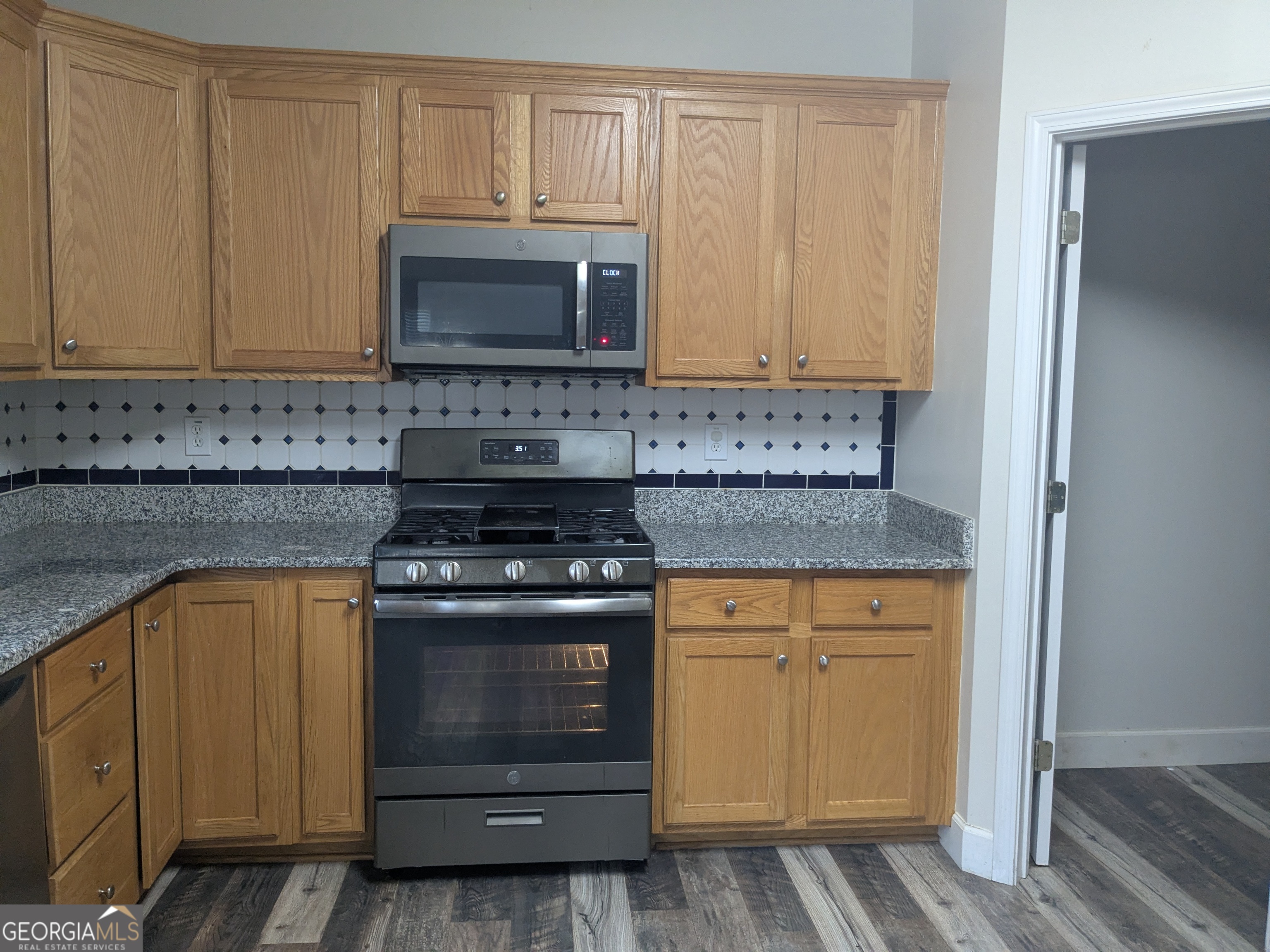 137 Village Green Circle Tyrone, GA 30290 - Photo 8 of 30 a kitchen with stainless steel appliances granite countertop a stove and a microwave