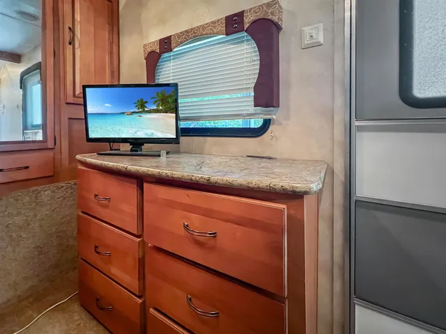 a view of kitchen with granite countertop cabinets and refrigerator