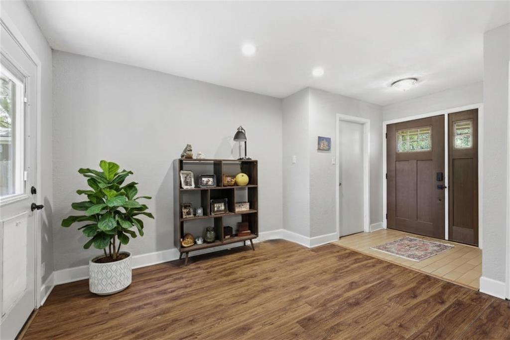 16 Coffee Tavern Road Bedford, TX 76022 - Photo 4 of 24 Entryway featuring wood-finish flooring, a wood-panel front door with glass inserts, and a coordinating sidelight