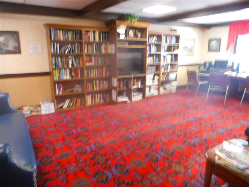 3760 Inverrary Drive, Unit N 1Y Lauderhill, FL 33319 - Photo 15 of 28 a living room with furniture a rug and a book shelf