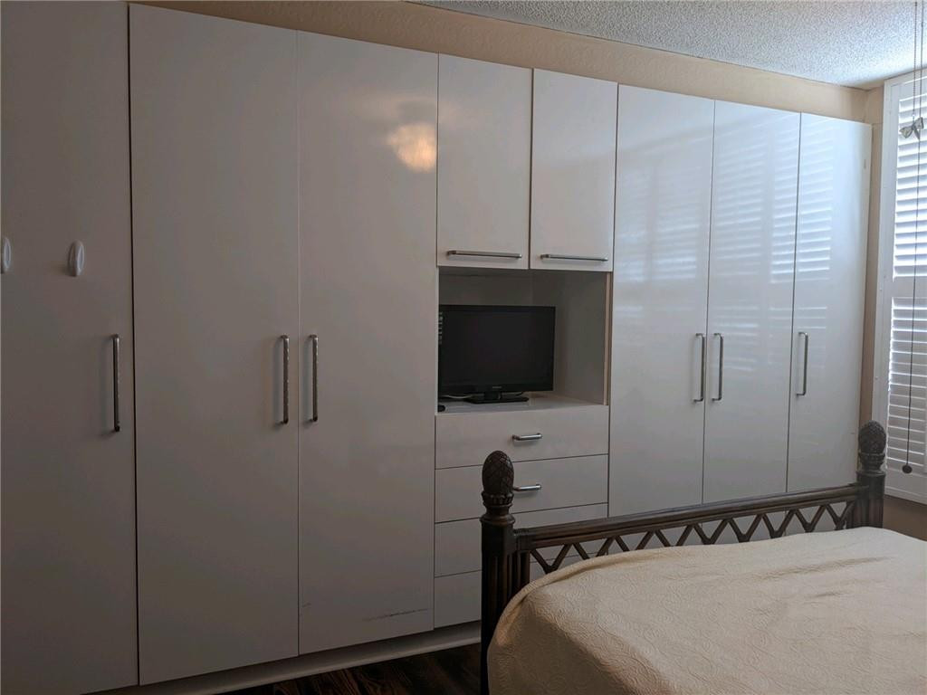 3760 Inverrary Drive, Unit N 1Y Lauderhill, FL 33319 - Photo 5 of 28 a bedroom with a bed and a flat tv screen on the dresser