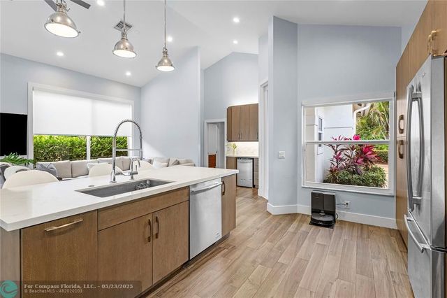 a kitchen with a sink window and wooden floor