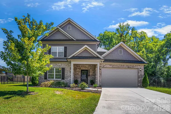 a front view of a house with a garden and yard