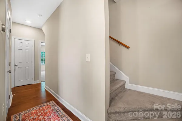 a view of hallway with stairs and wooden floor