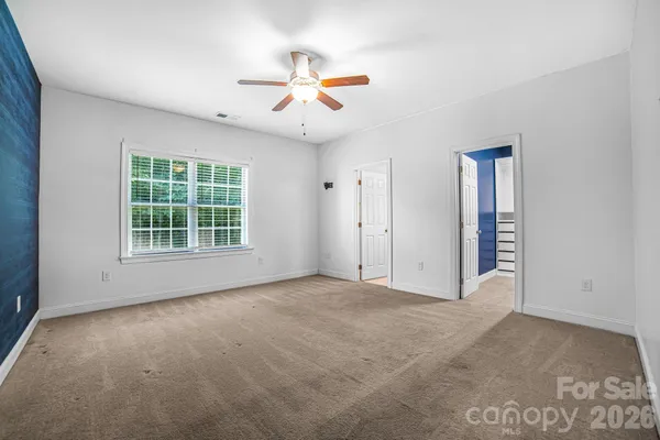an empty room with windows and cabinet