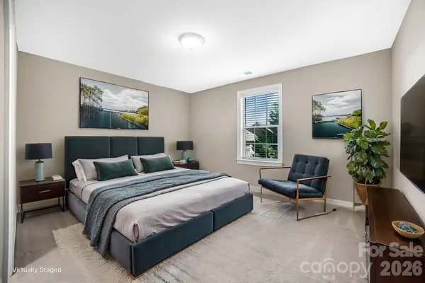 a bedroom with a bed a couch and a potted plant