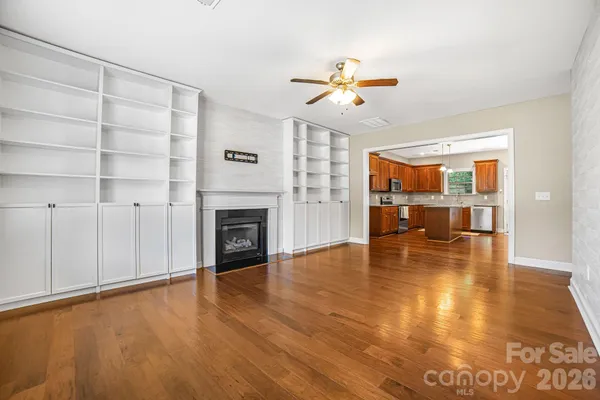 a view of empty room with wooden floor and fireplace