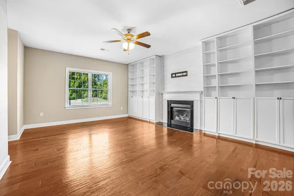 a view of an empty room with a fireplace and a window