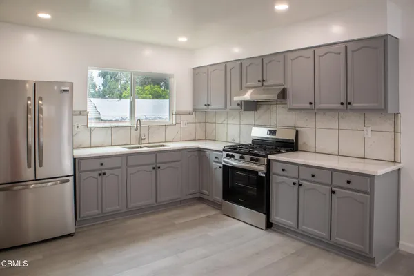 a kitchen with stainless steel appliances granite countertop a refrigerator sink and cabinets