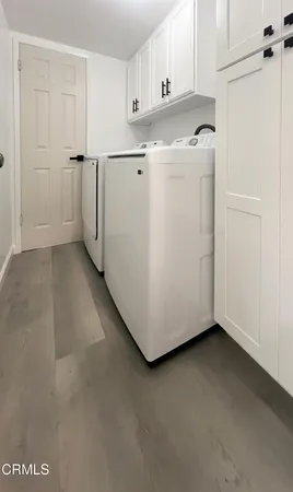 a view of a kitchen with closet and white cabinets