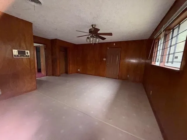 an empty room with windows and fan