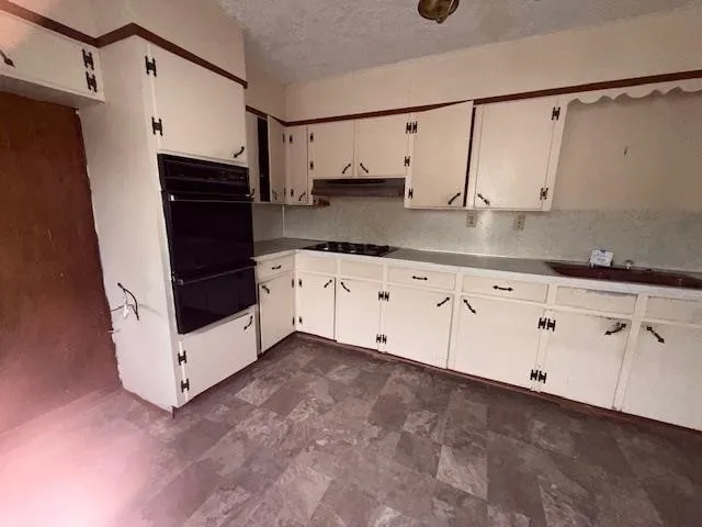 a kitchen with granite countertop white cabinets and white appliances