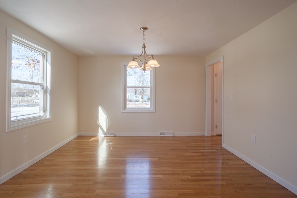98 Indian Run Road Bellingham, MA 02019 - Photo 10 of 30 an empty room with wooden floor windows and exposed bricks
