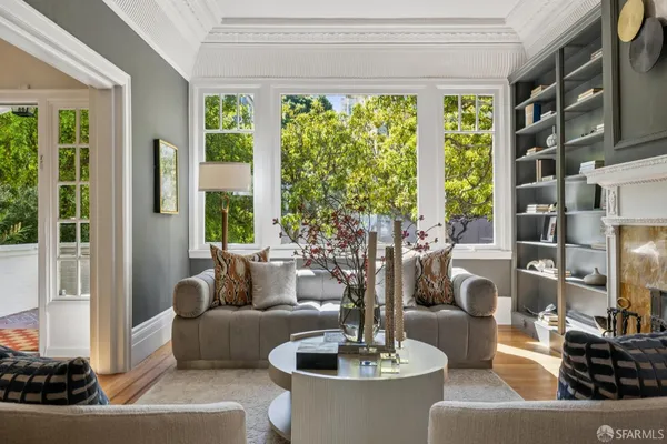 a view of a dining room and livingroom with furniture wooden floor a chandelier