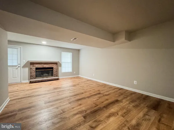 a big room with wooden floor and a fireplace
