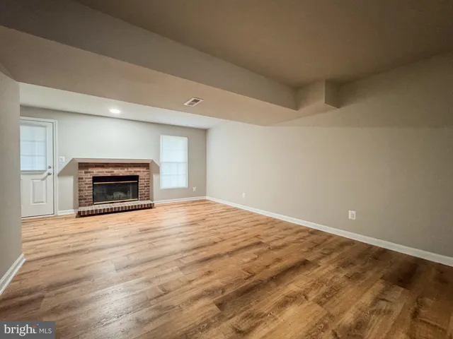 a big room with wooden floor and a fireplace