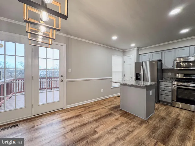 a kitchen with stainless steel appliances granite countertop a refrigerator and a stove top oven