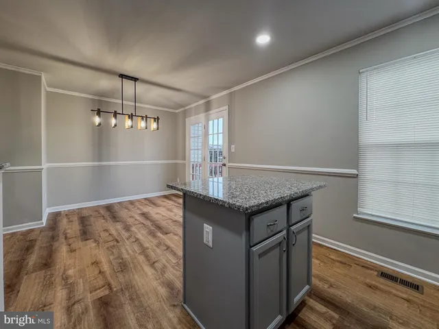 a view of kitchen island a wooden floor and window