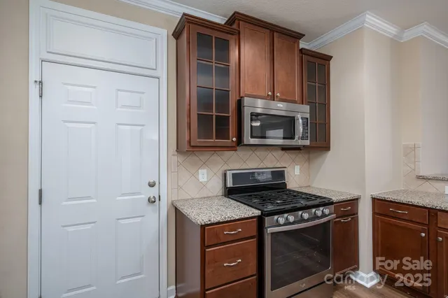 a kitchen with stainless steel appliances granite countertop white cabinets and black stove top oven with granite countertops