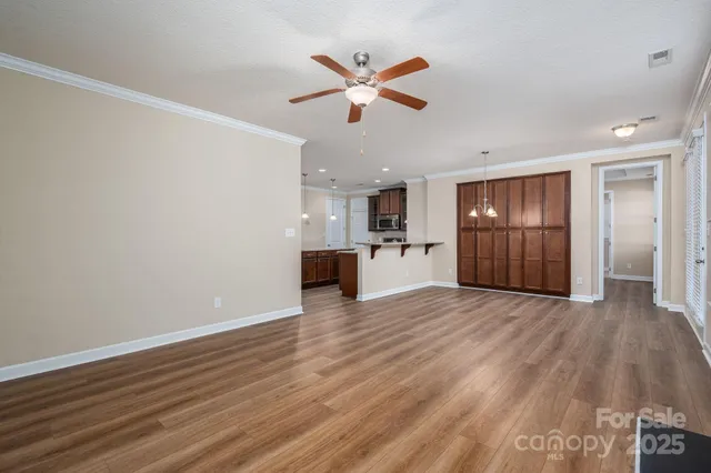 a view of an empty room with window and wooden floor