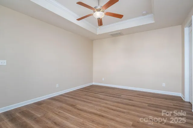 a view of room with wooden floor and ceiling fan