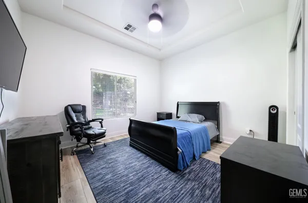 a bedroom with a bed wooden floor and a fireplace
