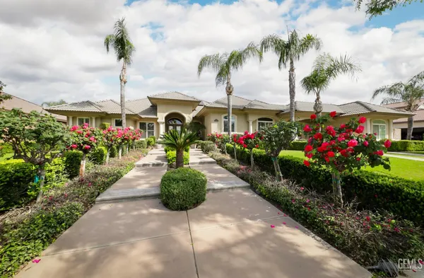 a front view of a house with a garden and seating area