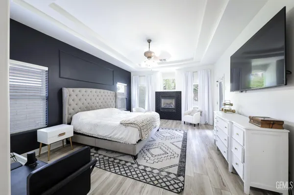 a backyard of a house with plants and large tree