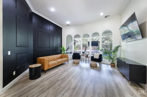 a large kitchen with granite countertop a large stove top oven a sink dishwasher and white cabinets with wooden floor