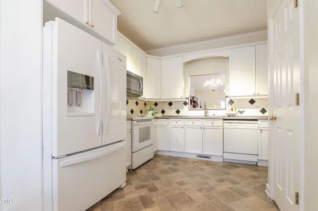 a kitchen with white cabinets and white appliances