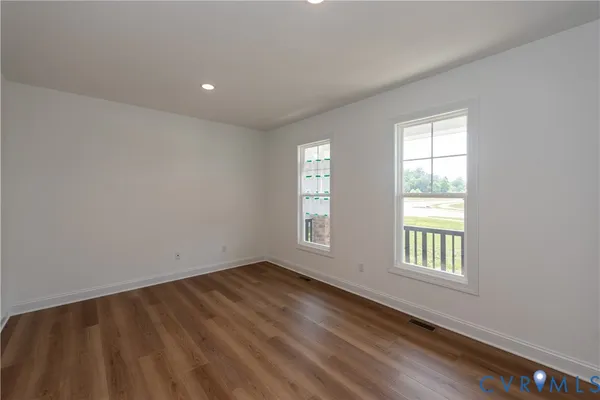a view of a room with wooden floor chandelier and a window