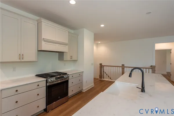 an empty room with wooden floor fireplace and windows