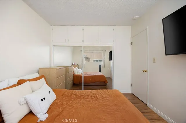 a bedroom with a large bed and a flat tv screen