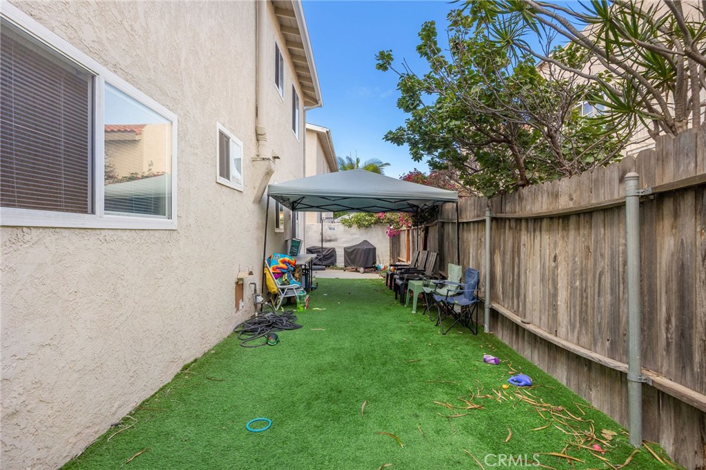 2615 Rockefeller Lane Redondo Beach, CA 90278 - Photo 26 of 33 a view of a backyard with table and chairs under an umbrella with wooden fence