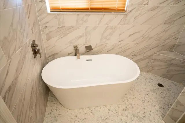 an empty room with wooden floor cabinet and windows