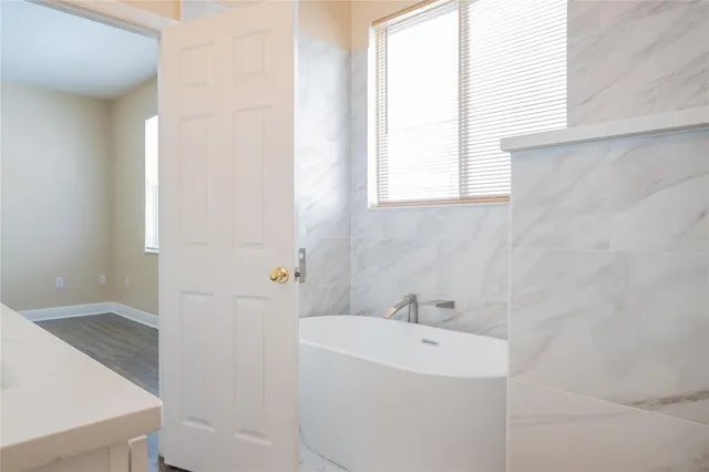 a view of an empty room with wooden floor and closet