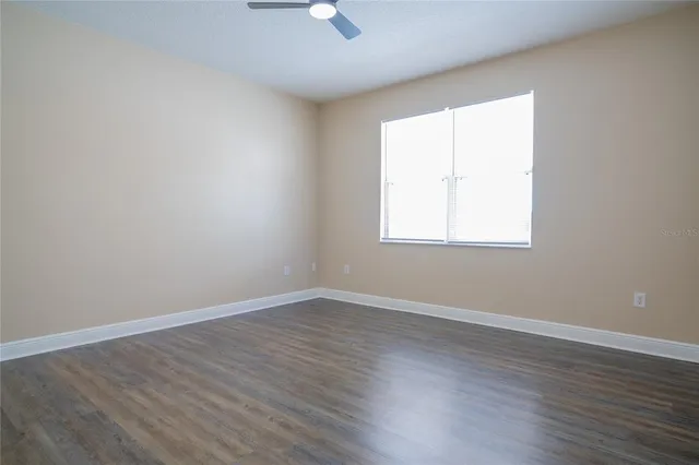 an empty room with wooden floor and closet area