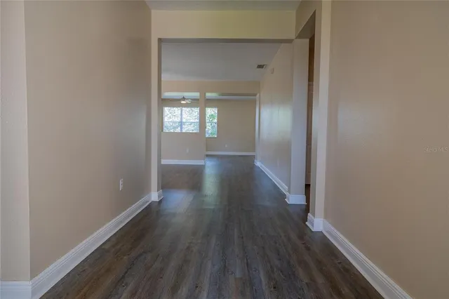 a view of a hallway with wooden floor and staircase