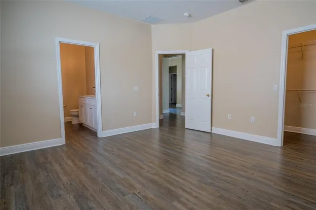 a large kitchen with stainless steel appliances granite countertop a refrigerator oven a sink dishwasher and a refrigerator with wooden floor