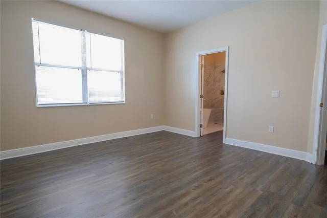 a kitchen with granite countertop wooden floors white cabinets and stainless steel appliances