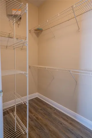 a kitchen with stainless steel appliances granite countertop a stove a sink dishwasher and a refrigerator with wooden floor