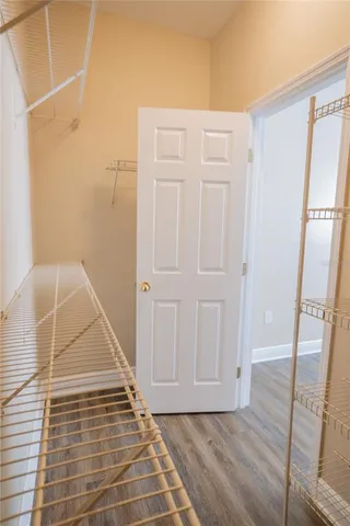 a view of an empty room with furniture and a window
